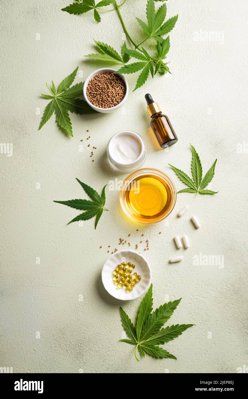 Hemp oil, leaves and products, cbd oil in bottle and capsules, face creme and serum, alternative medicine and organic skin care concept. Stock Photo