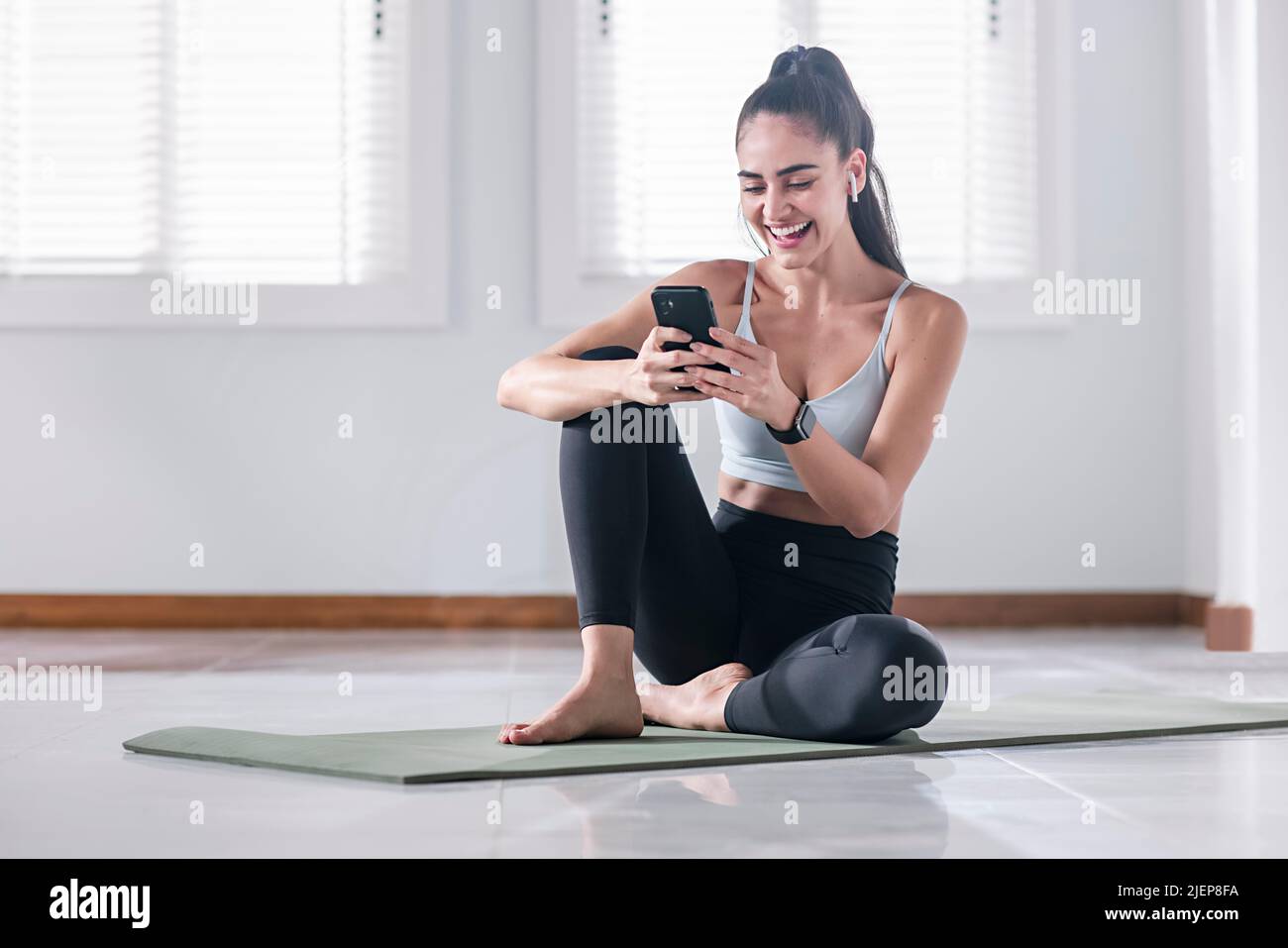 Young woman using a mobile phone post workout. High quality photo Stock Photo