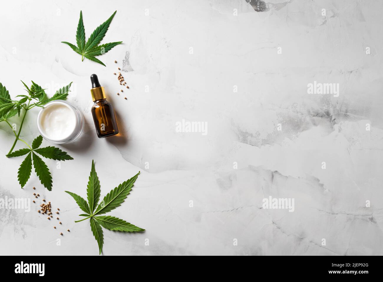 Hemp cannabis oil, leaves and beauty products, cbd oil in bottle, face creme and serum, alternative medicine and organic skin care concept. Copy space Stock Photo