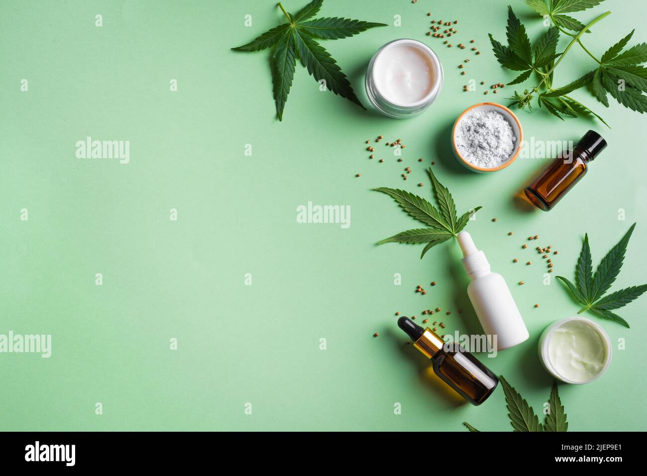 Hemp cannabis  leaves and beauty products, cbd oil in bottle, face creme and serum, alternative medicine and organic skin care concept. Copy space. Stock Photo