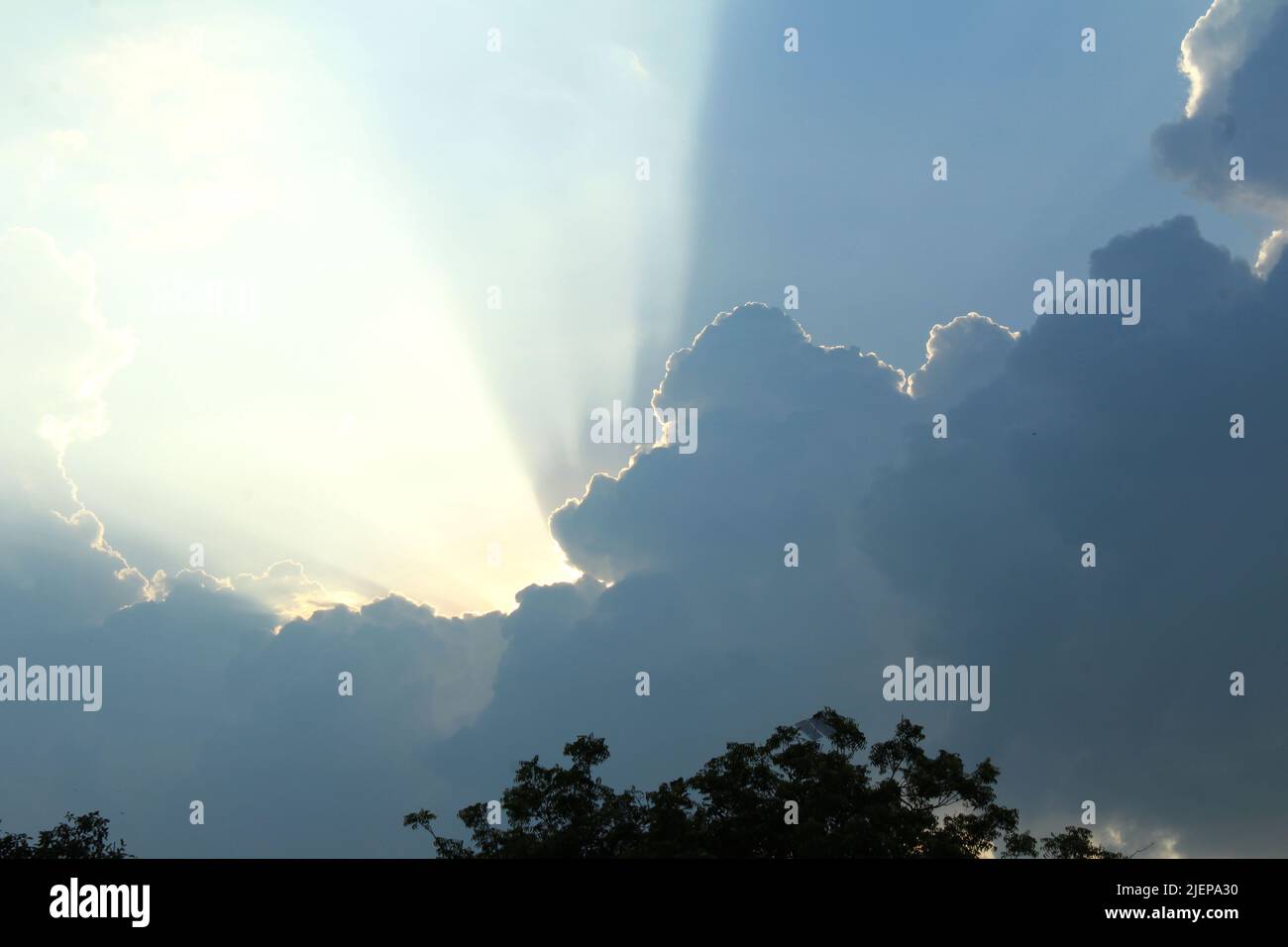 sun rays coming out from clouds Stock Photo