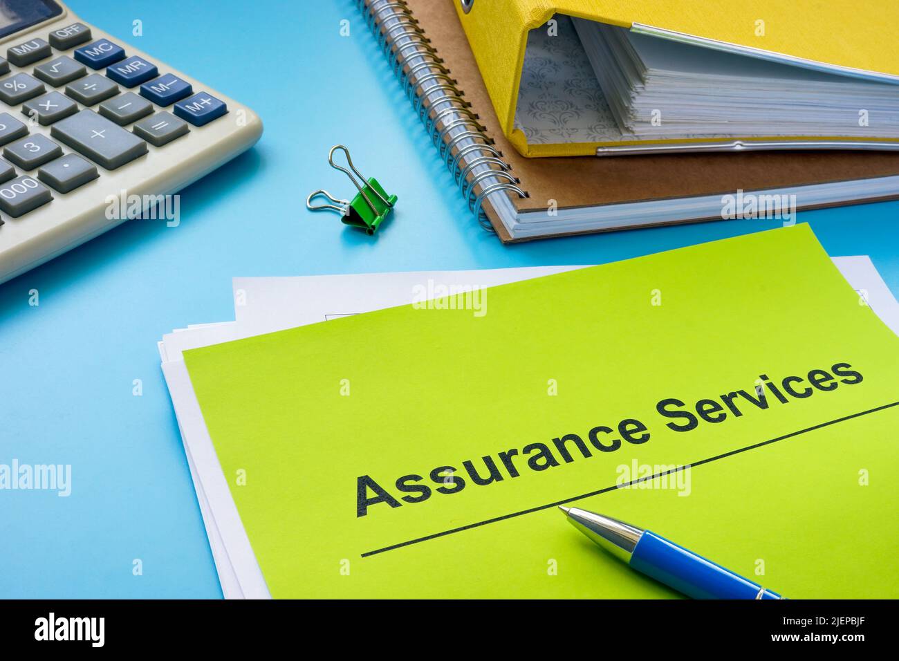 Pile of papers about assurance services and folder. Stock Photo