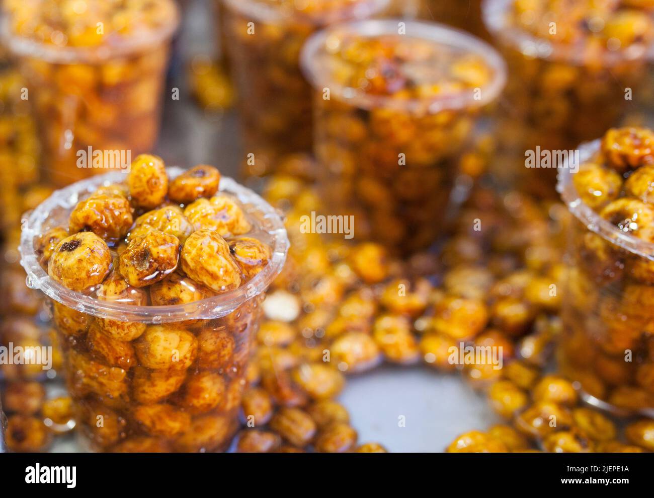 Glasses with tiger nuts or chufas. Water drops falling on cups displayed at street market stall Stock Photo