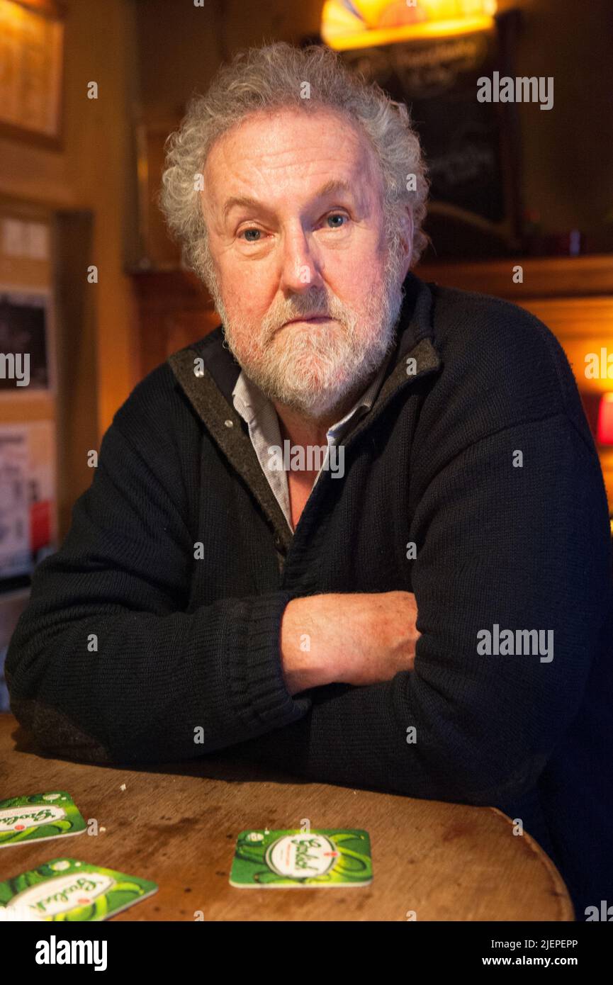 Tilburg, Netherlands. Senior adult male wearing beard and glasses hanging on Weemoed's Bar observing and being the former owner of the cafe establishment. Stock Photo