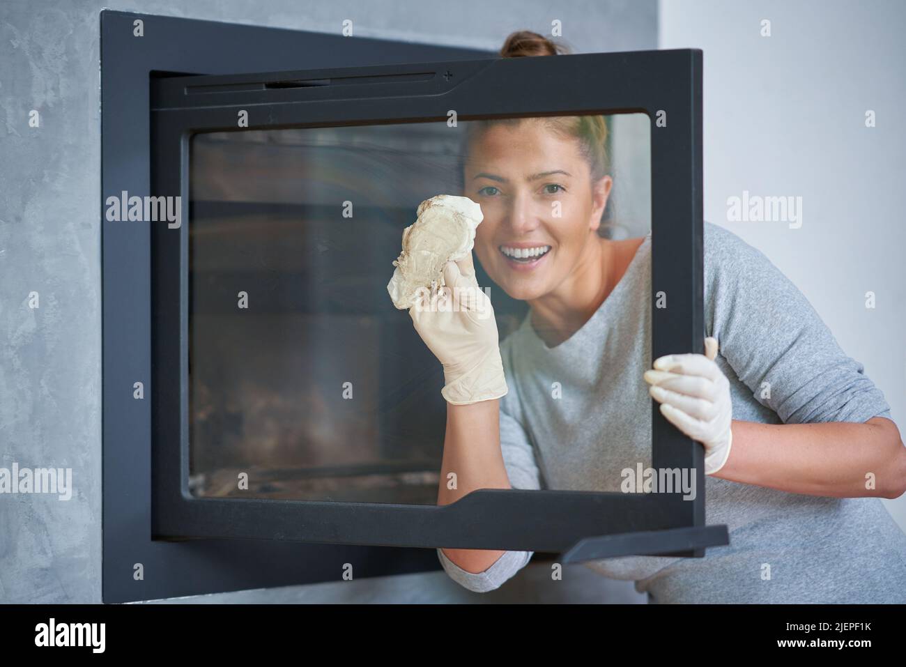 Picture of young woman cleaning fireplace glass doors Stock Photo Alamy