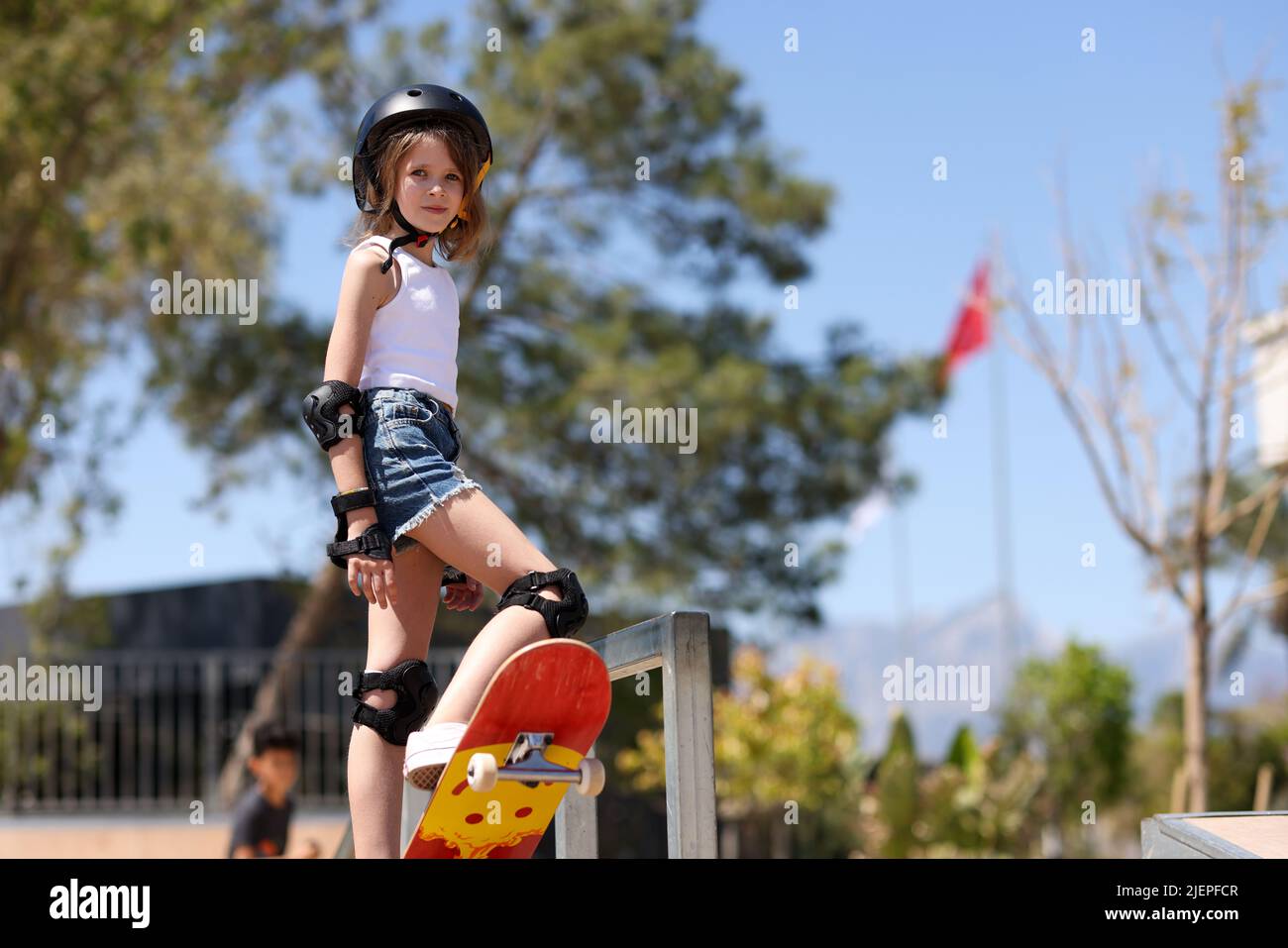 Child girl playing skateboarding in parking lot Stock Photo