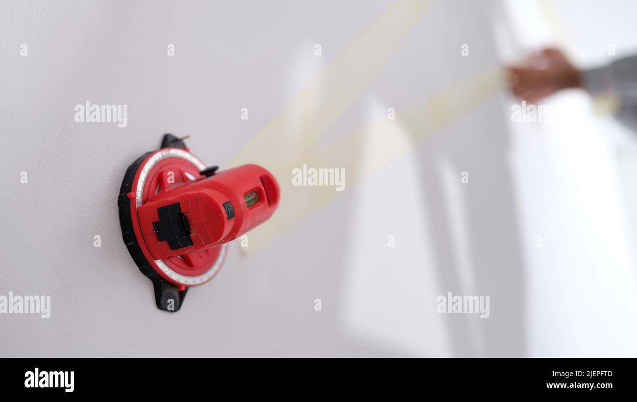 Laser level preparing wall for repair closeup Stock Photo Alamy