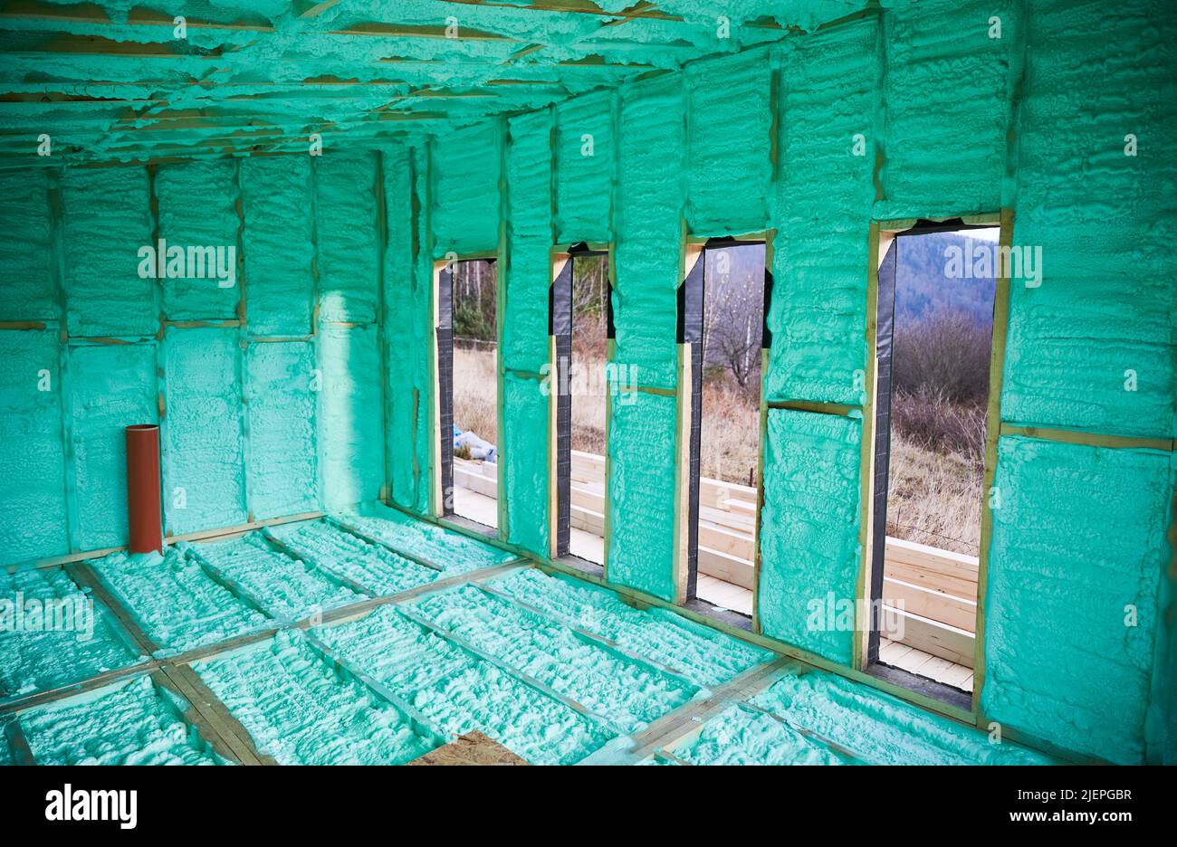 Wooden frame house thermal insulated by polyurethane foam. Construction and insulation concept. Stock Photo