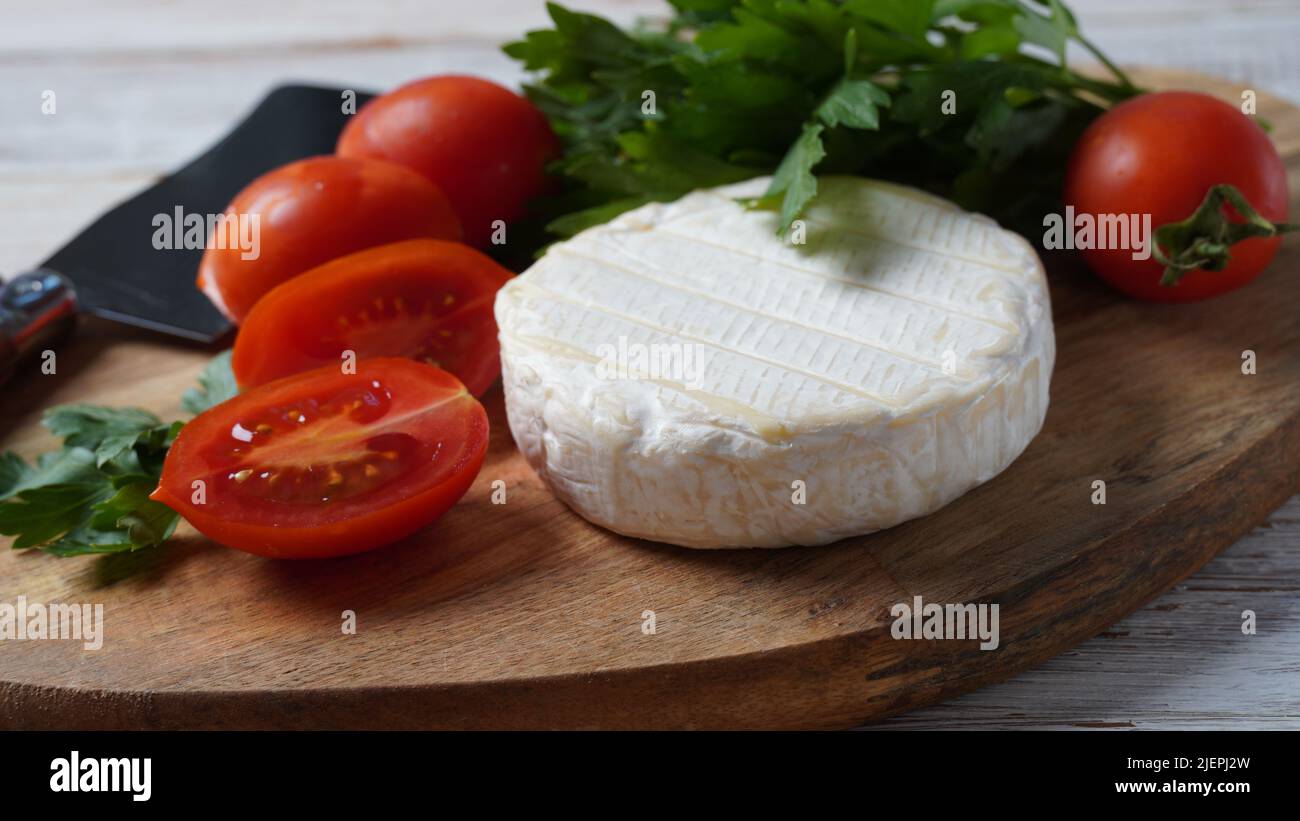 Camembert de Normandie cheese with cherry tomatoes herbs and cheese