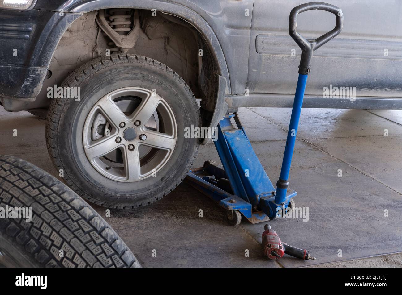 Jacking up a car to change a tyre after a roadside puncture with the