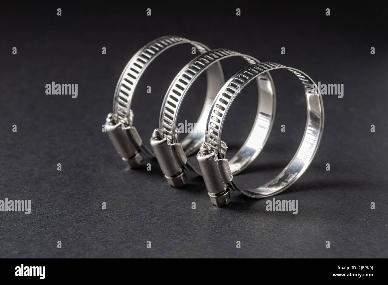 Metal hose clamp on black background. Empty space for text Stock Photo