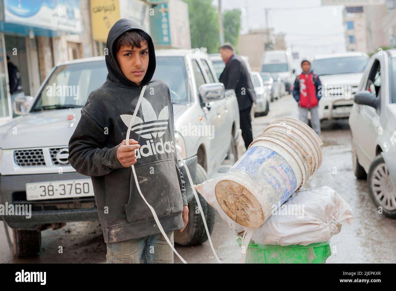 Al Mafraq, Jordan. Many Children and Teens, often refugee and migrant children from Syria, Iraq and Egypt have to do hard labour on the streets inside the informal economy to help their families earn a minimum living standard, which often tays below poverty lines. Stock Photo