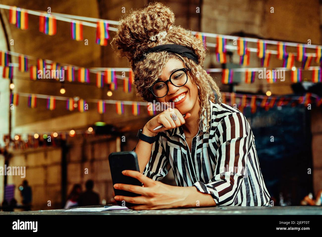 Portrait of smiling woman having video call on smartphone sitting in a coffeehouse shot Stock Photo