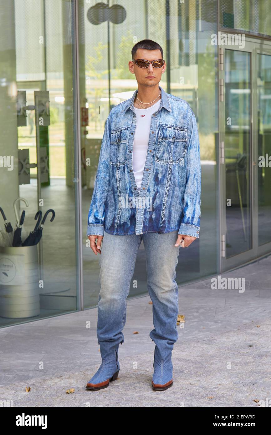 MILAN, ITALY - JUNE 19, 2022: Man with blue denim jacket and trousers and white Diesel shirt before Etro fashion show, Milan Fashion Week street style Stock Photo