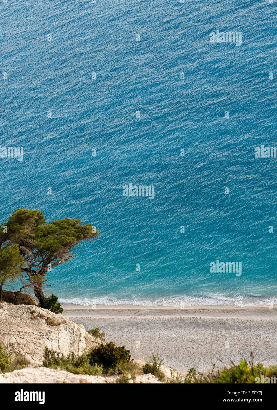 Beautiful wild Mediterranean pebble beach under a large massive cliff Stock Photo