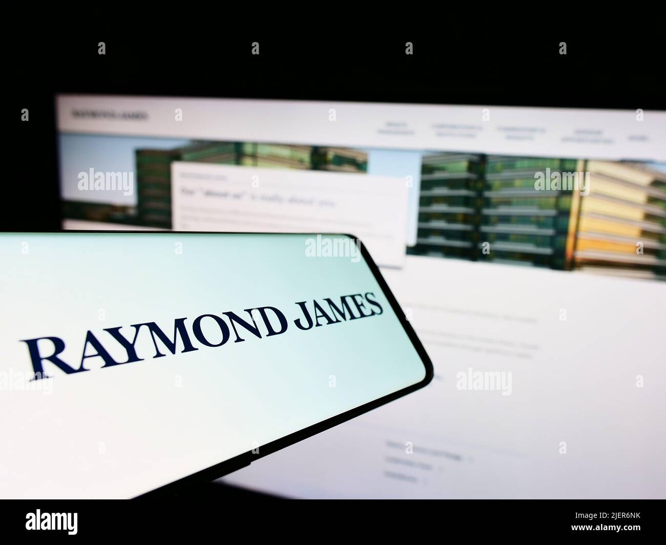 Smartphone with logo of American company Raymond James Financial Inc. on screen in front of website. Focus on center-right of phone display. Stock Photo