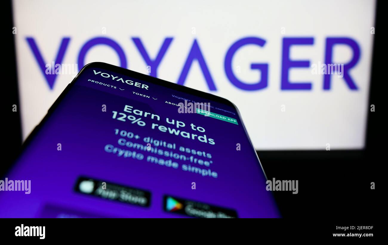 Smartphone with website of American cryptocurrency company Voyager Digital LLC on screen in front of logo. Focus on top-left of phone display. Stock Photo