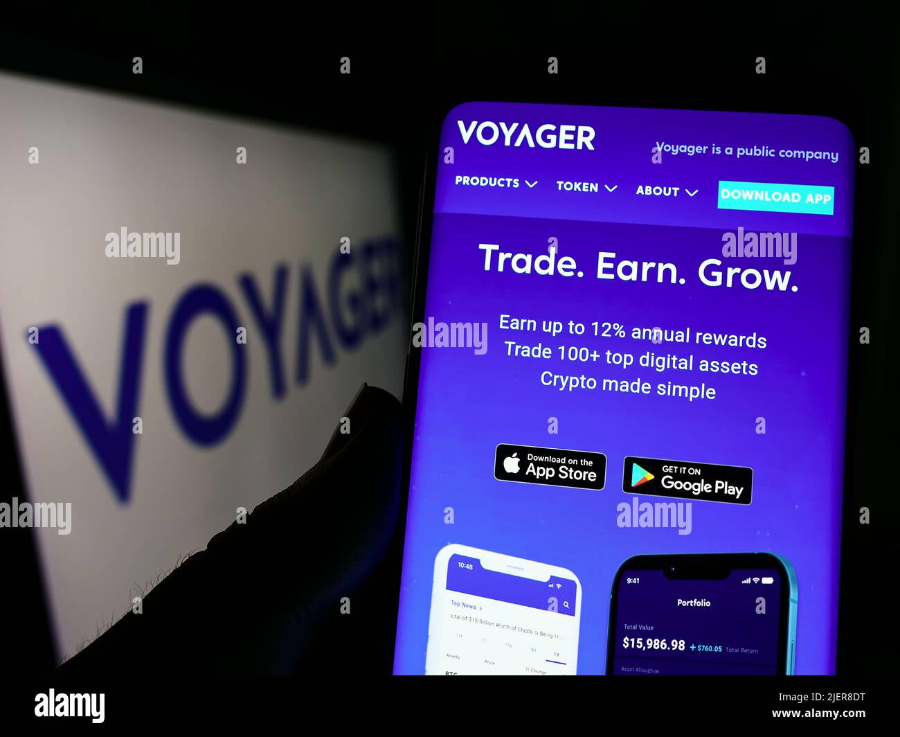 Person holding cellphone with webpage of US cryptocurrency company Voyager Digital LLC on screen with logo. Focus on center of phone display. Stock Photo