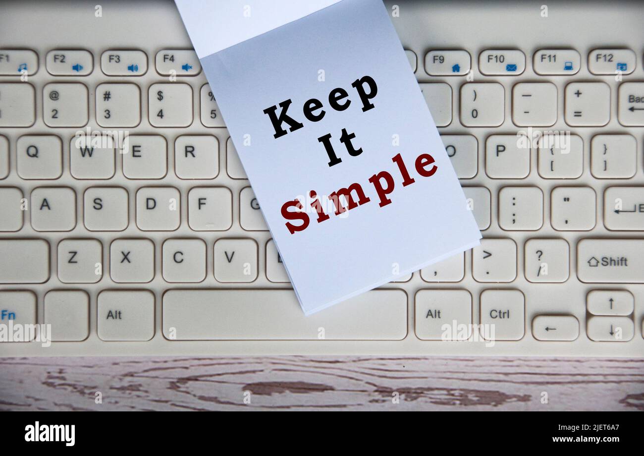 Top view of Keep it simple text on notepad on top of keyboard. Concept of simplicity Stock Photo