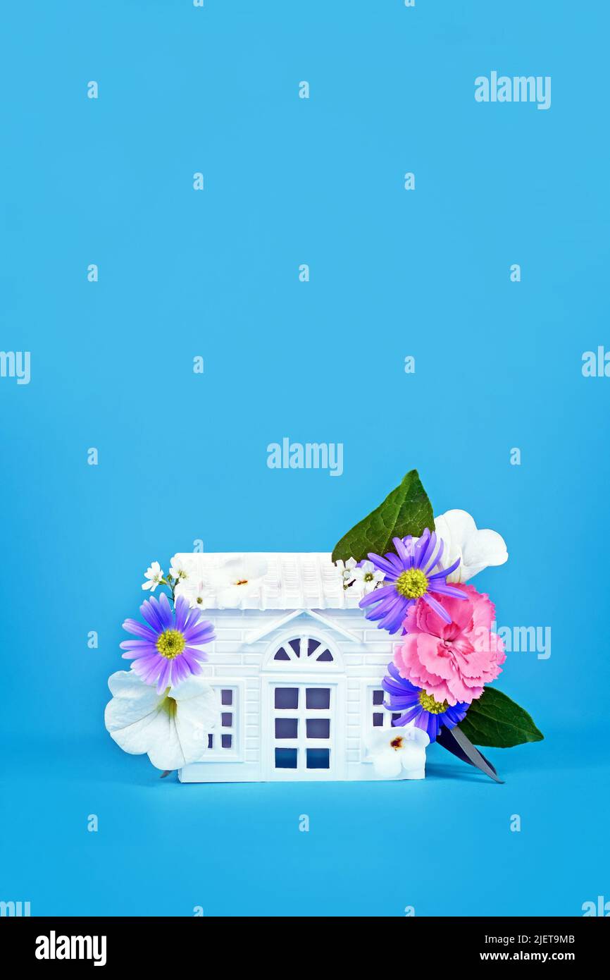 Concept for energy efficiency and carbon neutrality in buildings by using green construction designs and renewable energy showing house with flowers Stock Photo