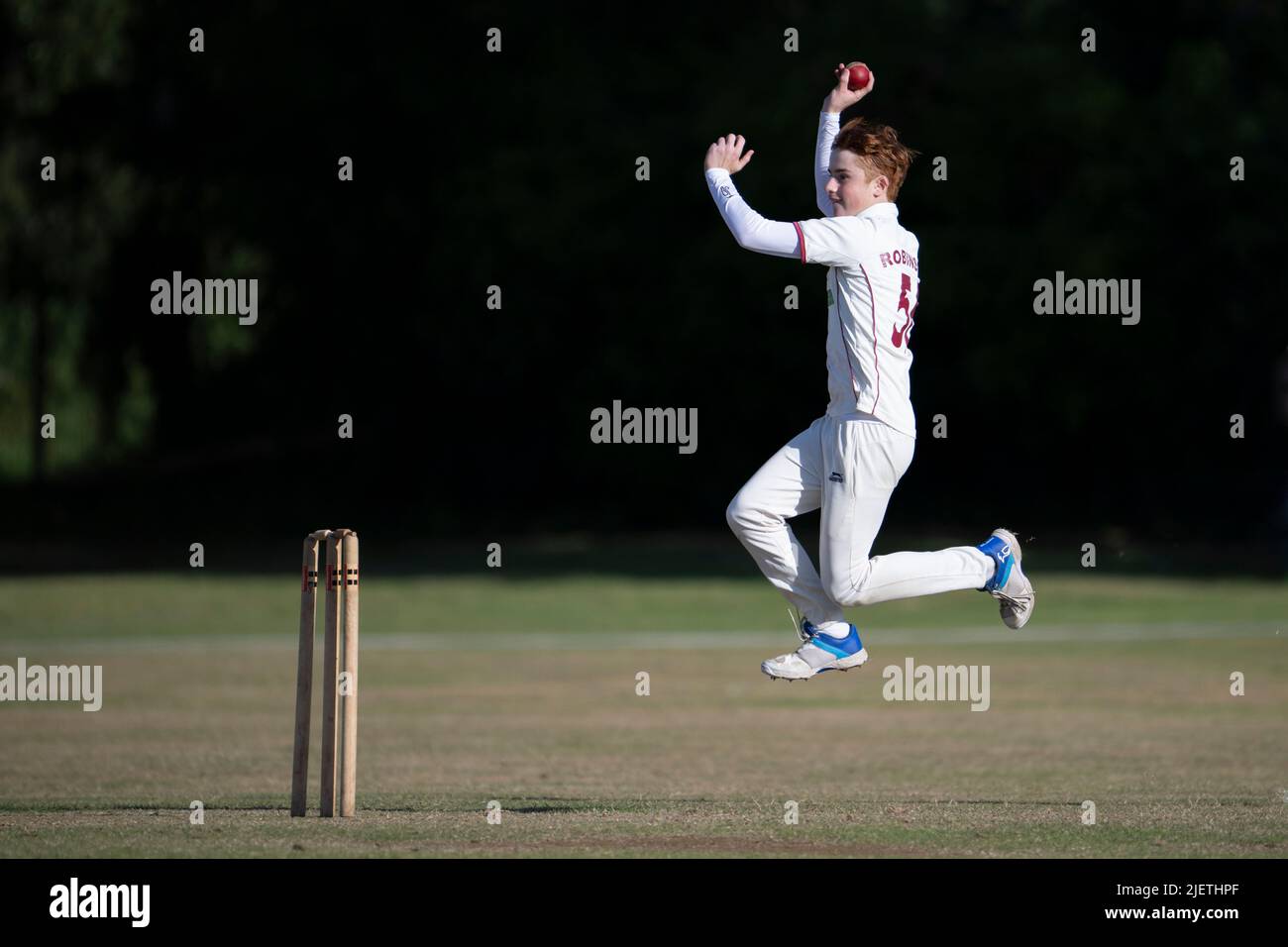 Teenage cricket bowler in action Stock Photo