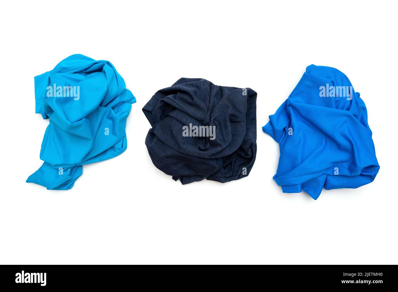 Three crumpled twisted blue sport t-shirts isolated on white, top view Stock Photo
