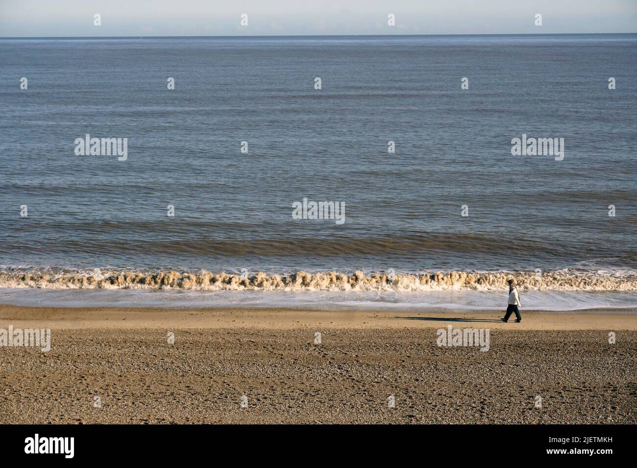 older couple walking along waterline sizewell beach suffolk england Stock Photo