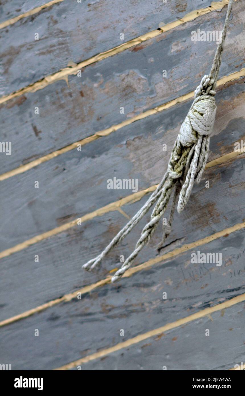 frayed piece of weathered twine hanging down side of freshly caulked