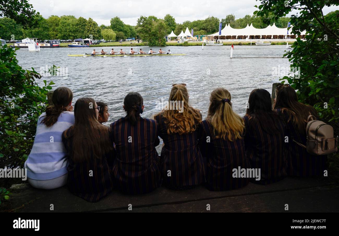People watch on from the river bank as St Paul's School compete on the opening day of the 2022 Henley Royal Regatta alongside the River Thames. Picture date: Tuesday June 28, 2022. Stock Photo