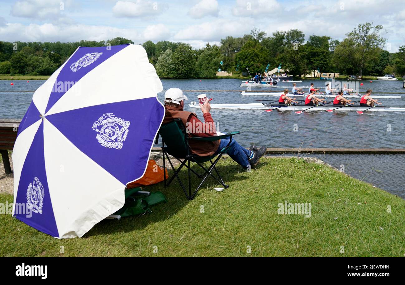 Spectators watch rowers from the river bank on the opening day of the 2022 Henley Royal Regatta alongside the River Thames. Picture date: Tuesday June 28, 2022. Stock Photo