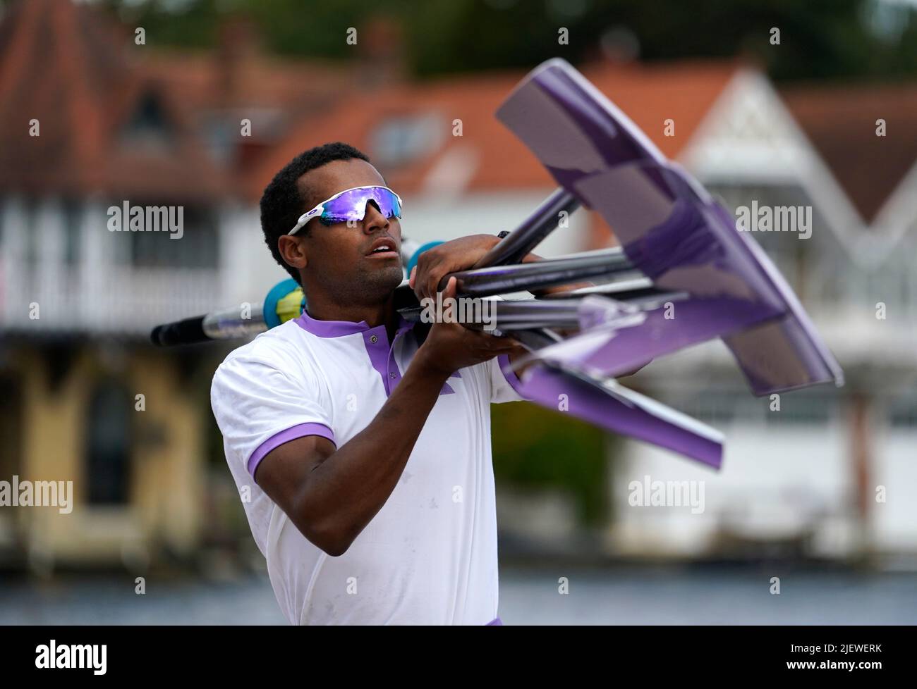 A member of Durham University 'A' crew carries rowing blades back to the boat house after competing on the opening day of the 2022 Henley Royal Regatta alongside the River Thames. Picture date: Tuesday June 28, 2022. Stock Photo