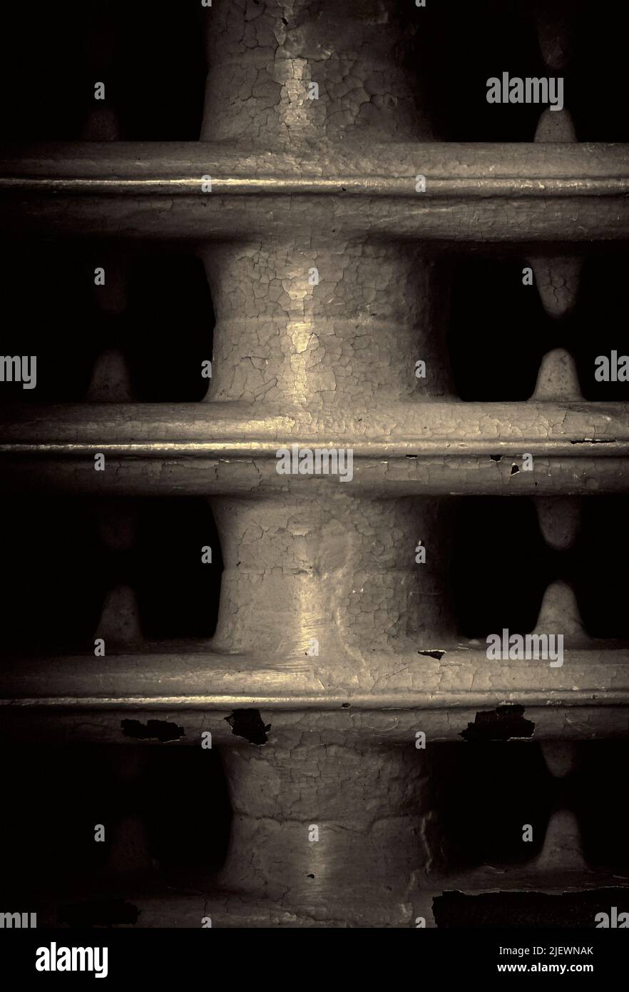 old fashioned cast iron radiator with flaking patinated paint Stock