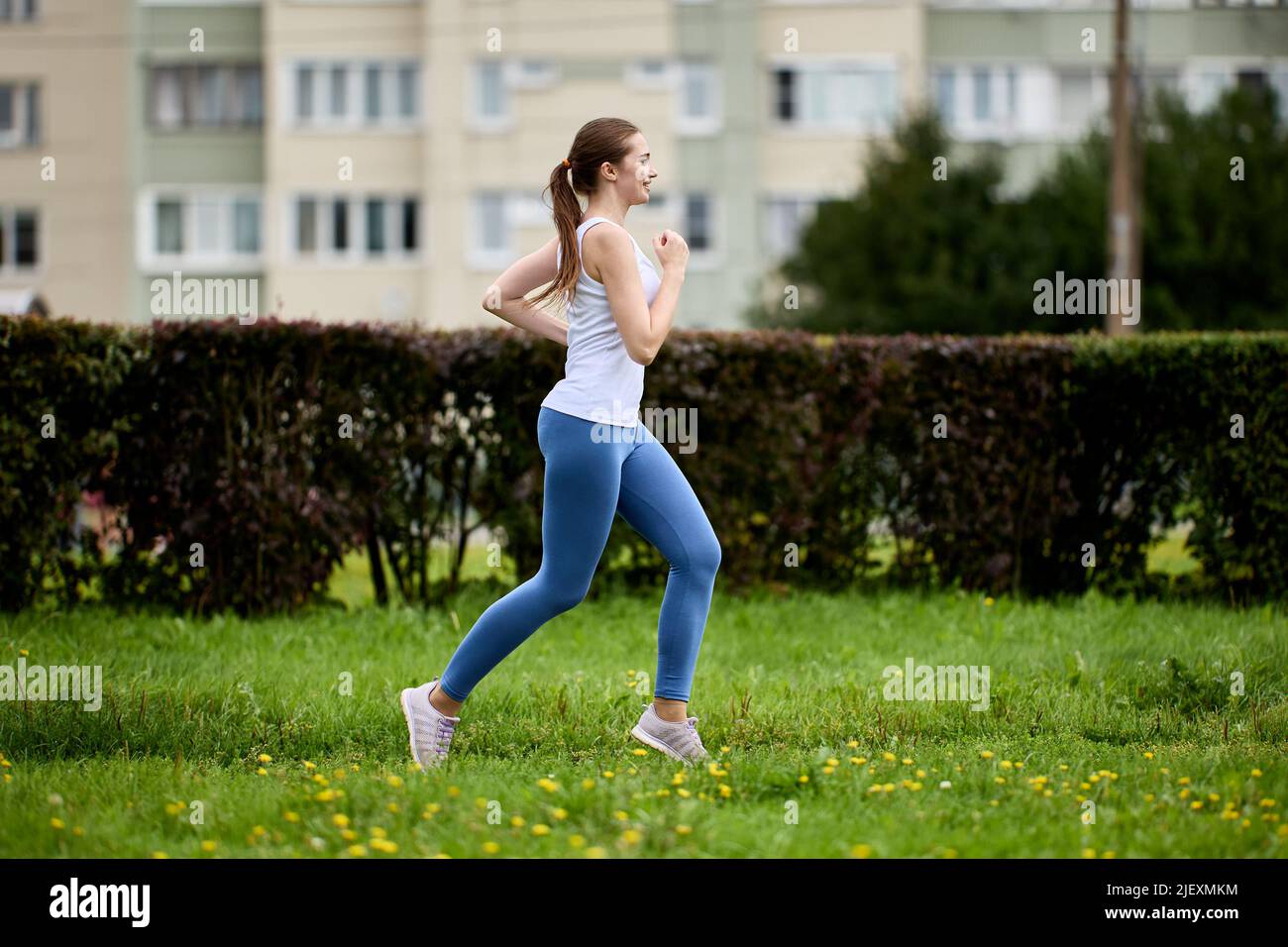 Woman 30 years old runs in city park. Stock Photo
