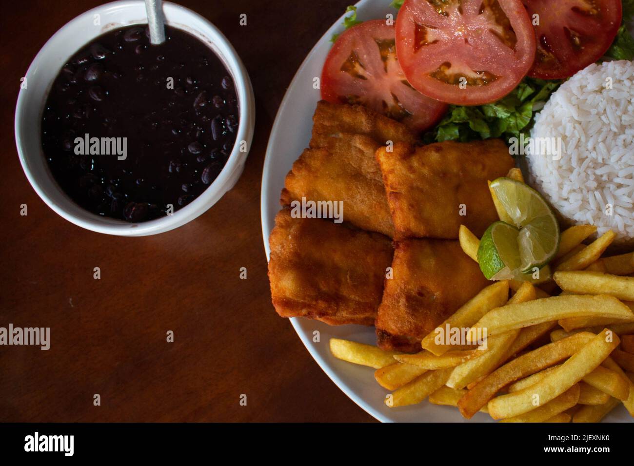 Close-up of typical Brazilian combo plate, rice, fried fish, french fries, salad and feijoada. Stock Photo