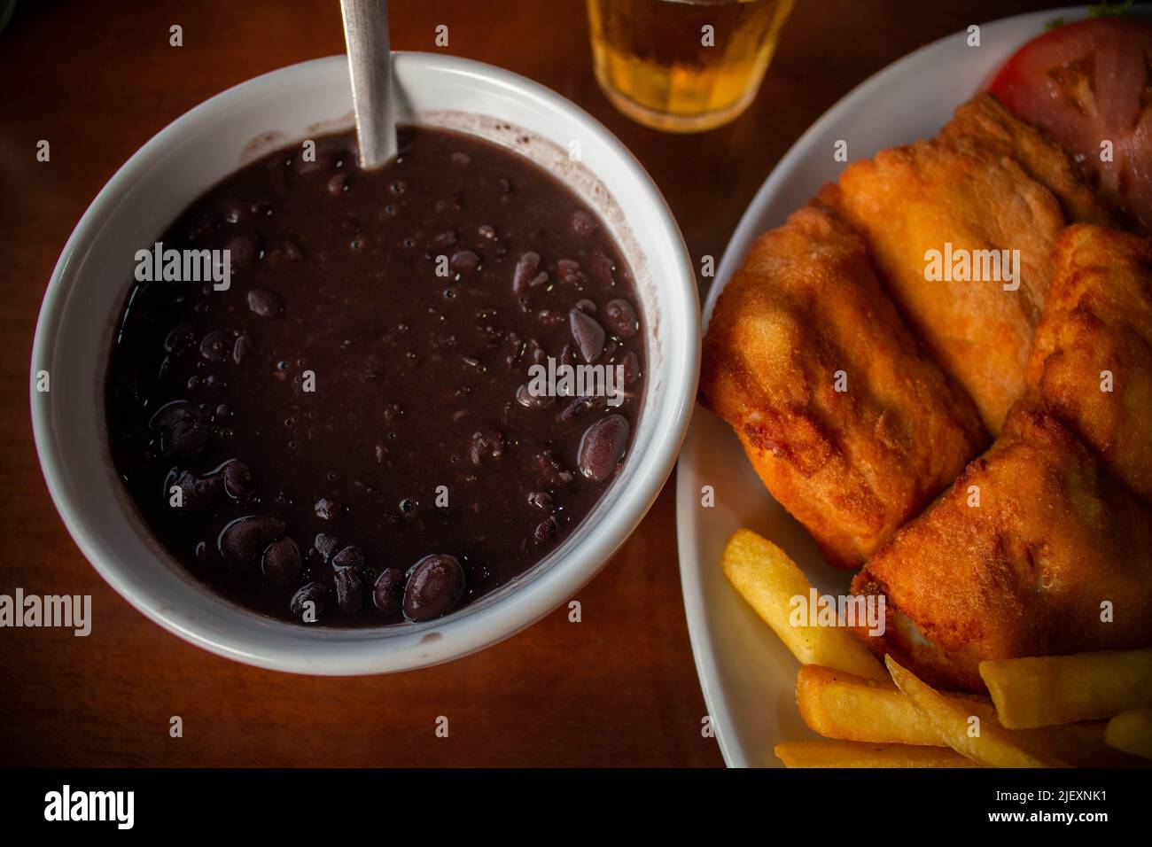 Close-up of typical Brazilian combo plate, rice, fried fish, french fries, salad and feijoada. Stock Photo