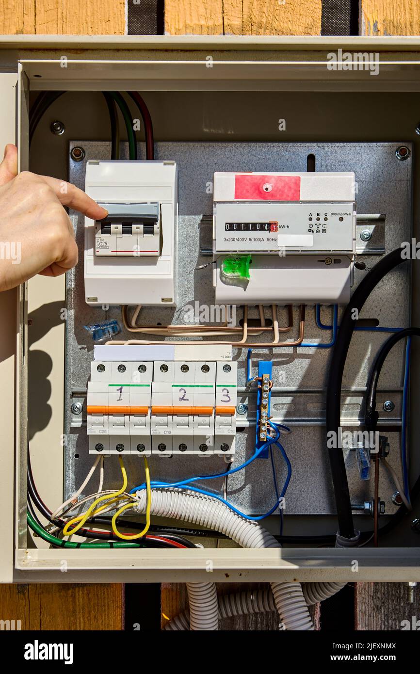 Turning circuit breaker in consumer unit with electrical meter Stock Photo Alamy