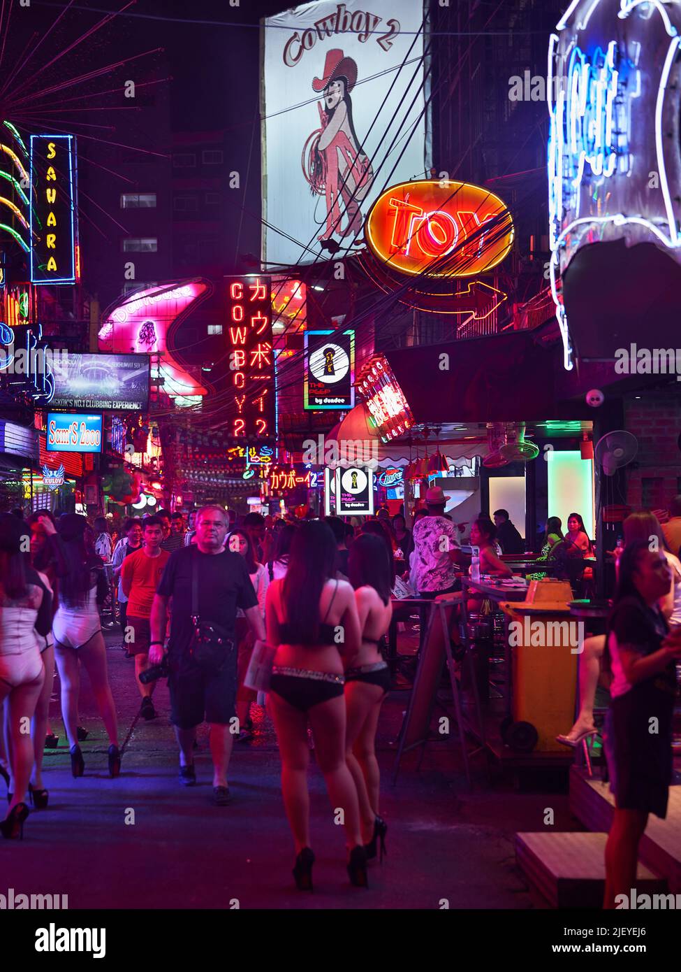 Tourist are walking around Soi Cowboy, one of Bangkok’s famous red light districts. Stock Photo