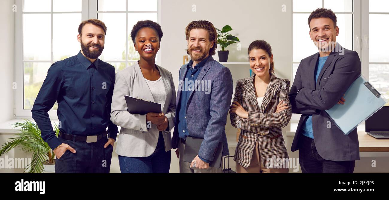 Team of cheerful confident successful business people standing in the office all together Stock Photo