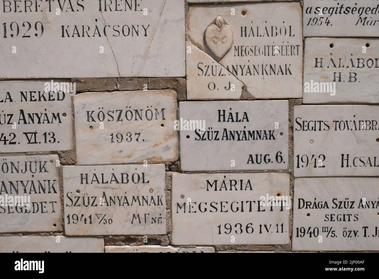 Memorial plaques on a wall next to the entrance gate, St Nicholas Catholic Church,  Szent Miklos templom, Kecskemet, Hungary Stock Photo