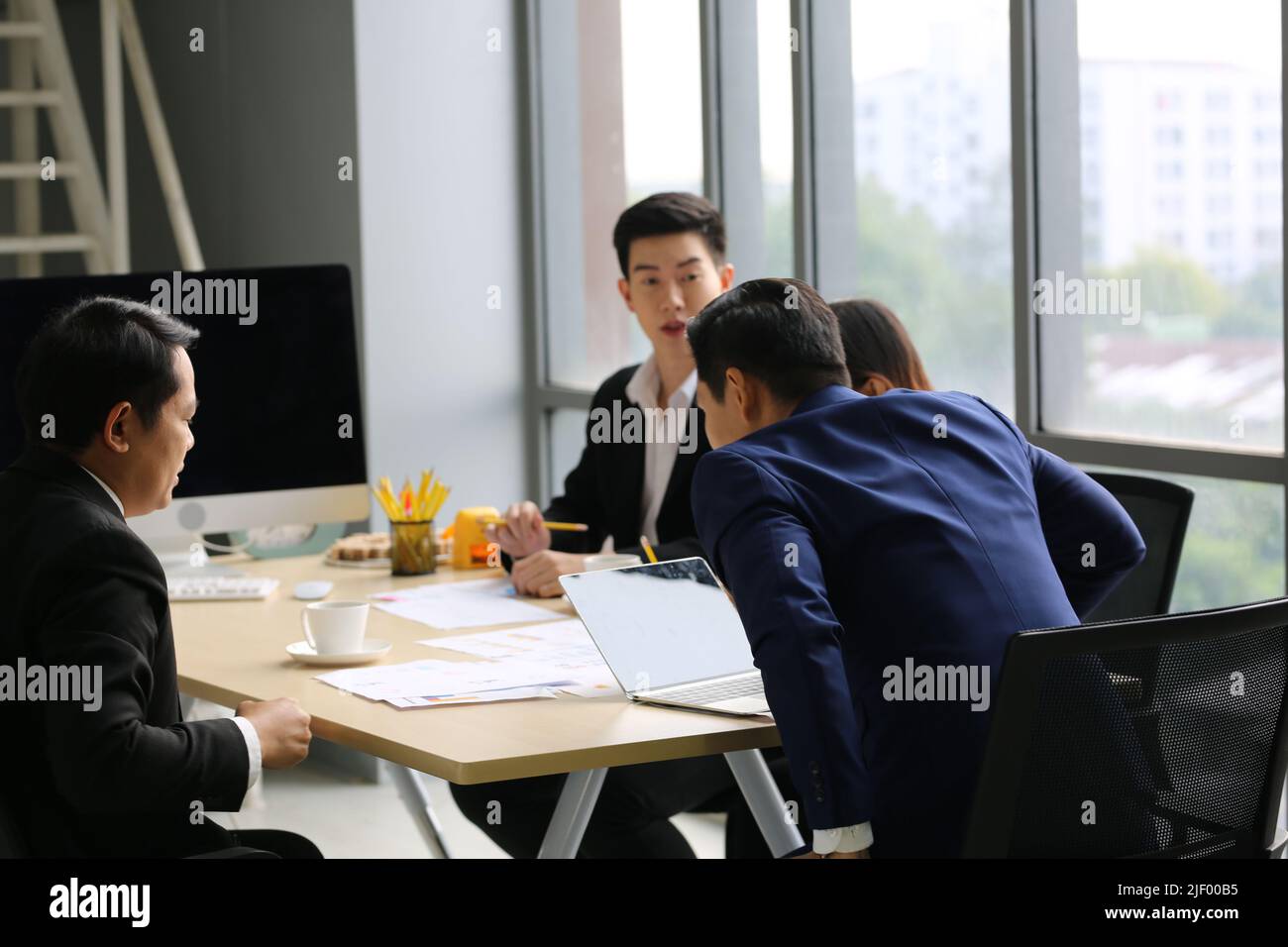 Businessman Giving Speech On Business Meeting With Colleagues, Discussing Work Ideas And Projects, Making Presentation Standing In Modern Office. Team Stock Photo