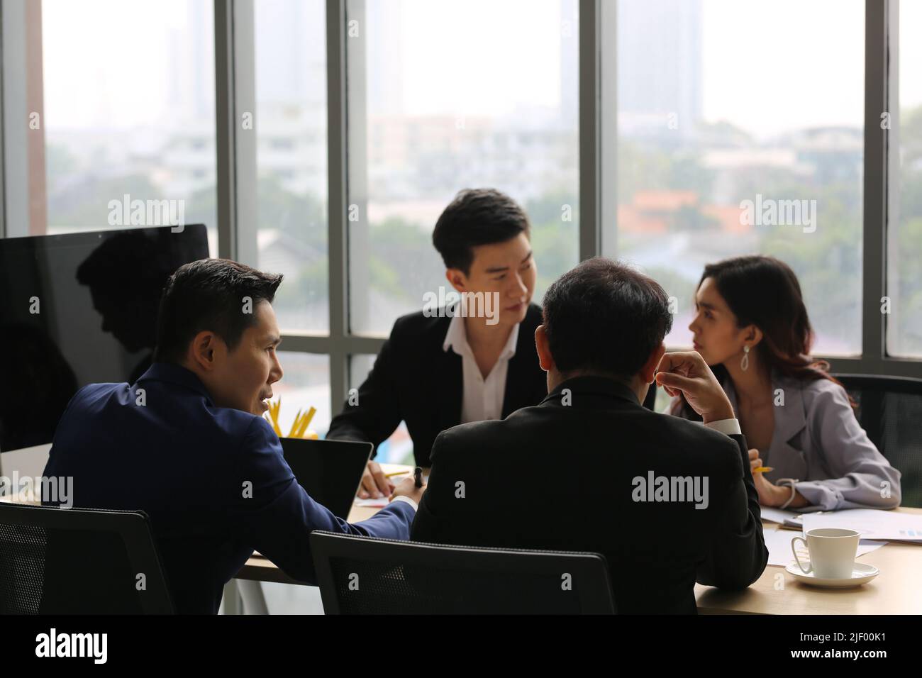 Businessman Giving Speech On Business Meeting With Colleagues, Discussing Work Ideas And Projects, Making Presentation Standing In Modern Office. Team Stock Photo