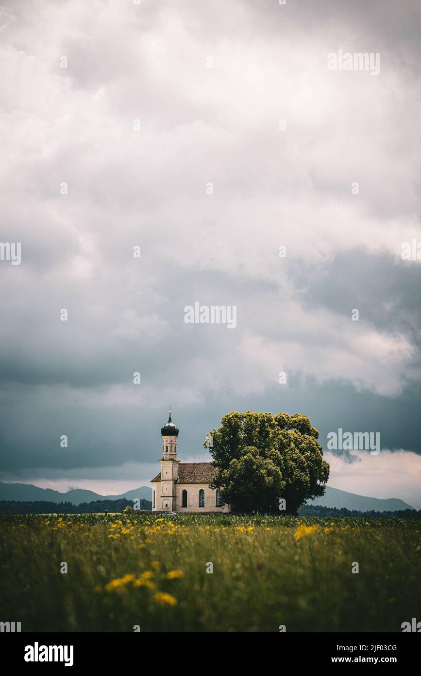 A vertical of the St. Andrae Church in a field in Etting, Pfaffenwinkel region, Upper Bavaria,Germany Stock Photo