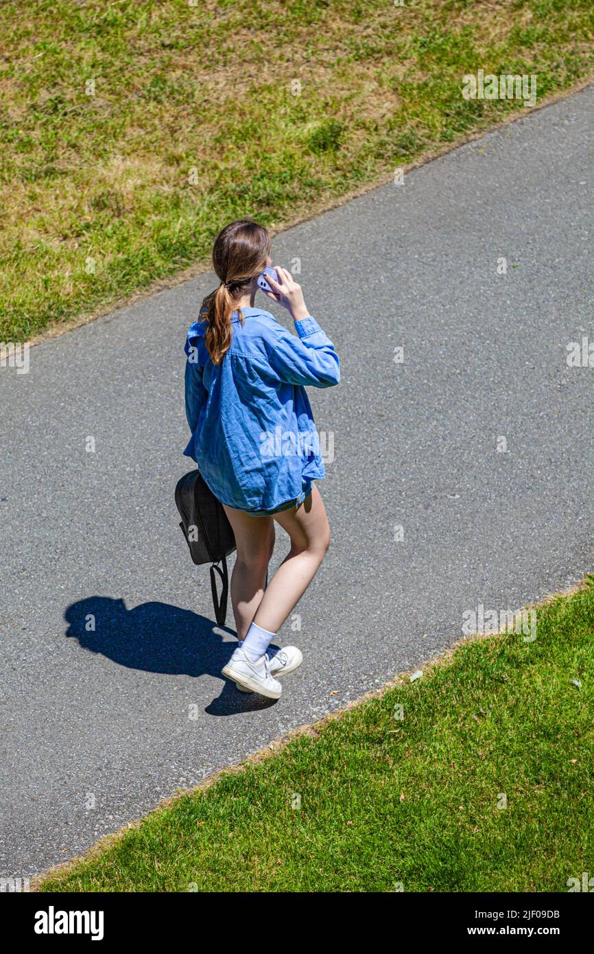 Young woman walking and talking on her phone in British Columbia Canada Stock Photo