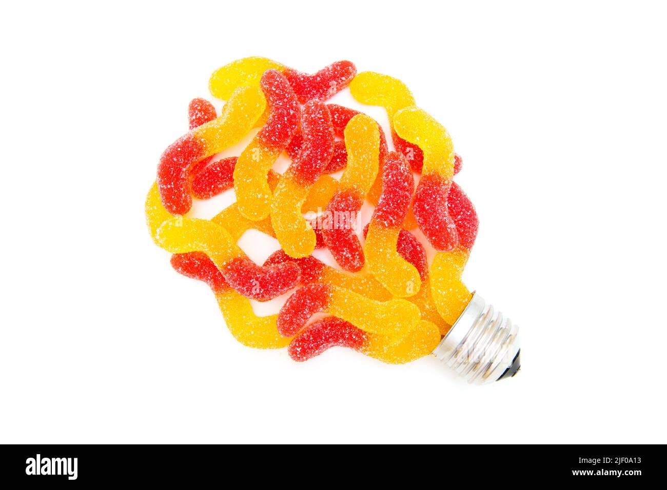 Lightbulb symbol made from gummy candies and screw base isolated on white background. Sweet food for mental boost and idea development. Stock Photo