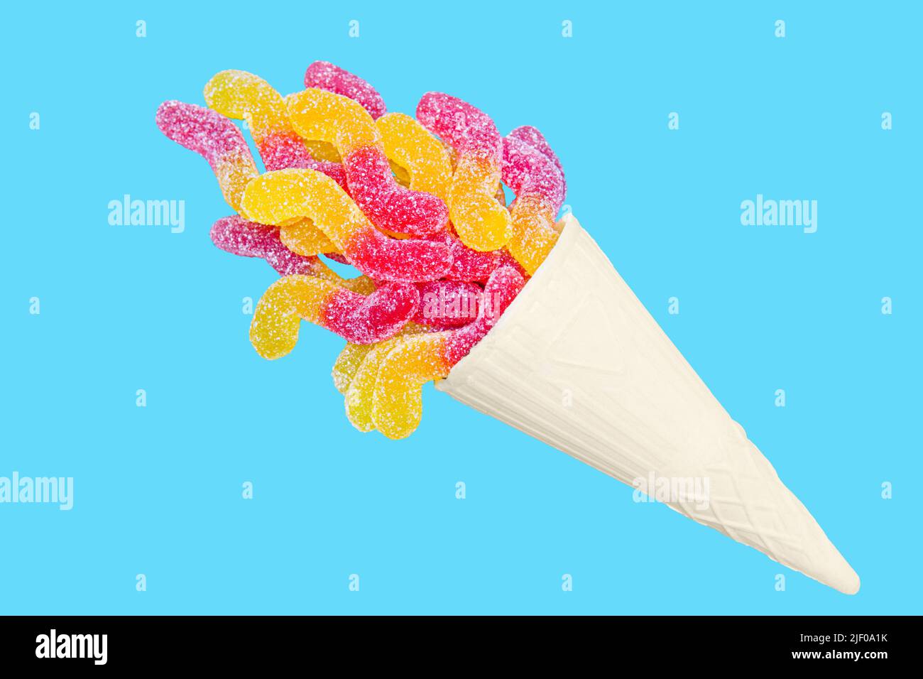 Vivid summer dessert: colorful z-shaped jelly worms in a waffle cone