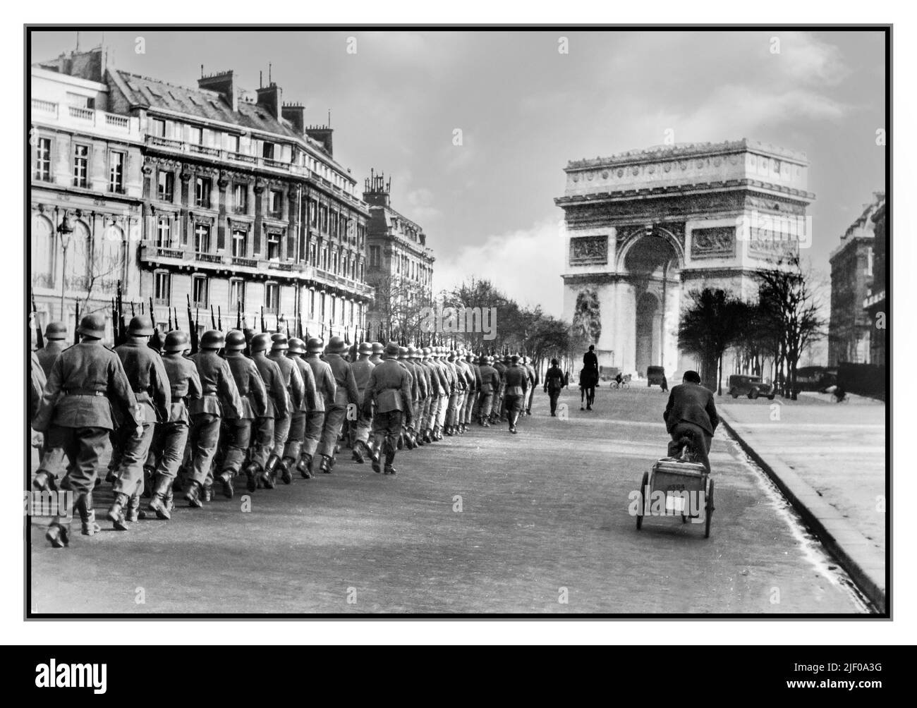 PARIS NAZI GERMANY OCCUPATION WW2  June 14, 1940, Nazi Wehrmacht troops march into Paris without a fight. It was declared an open city by the French government in order to avoid its destruction. Arc de Triomphe in background Paris France. World War II Second World War Stock Photo
