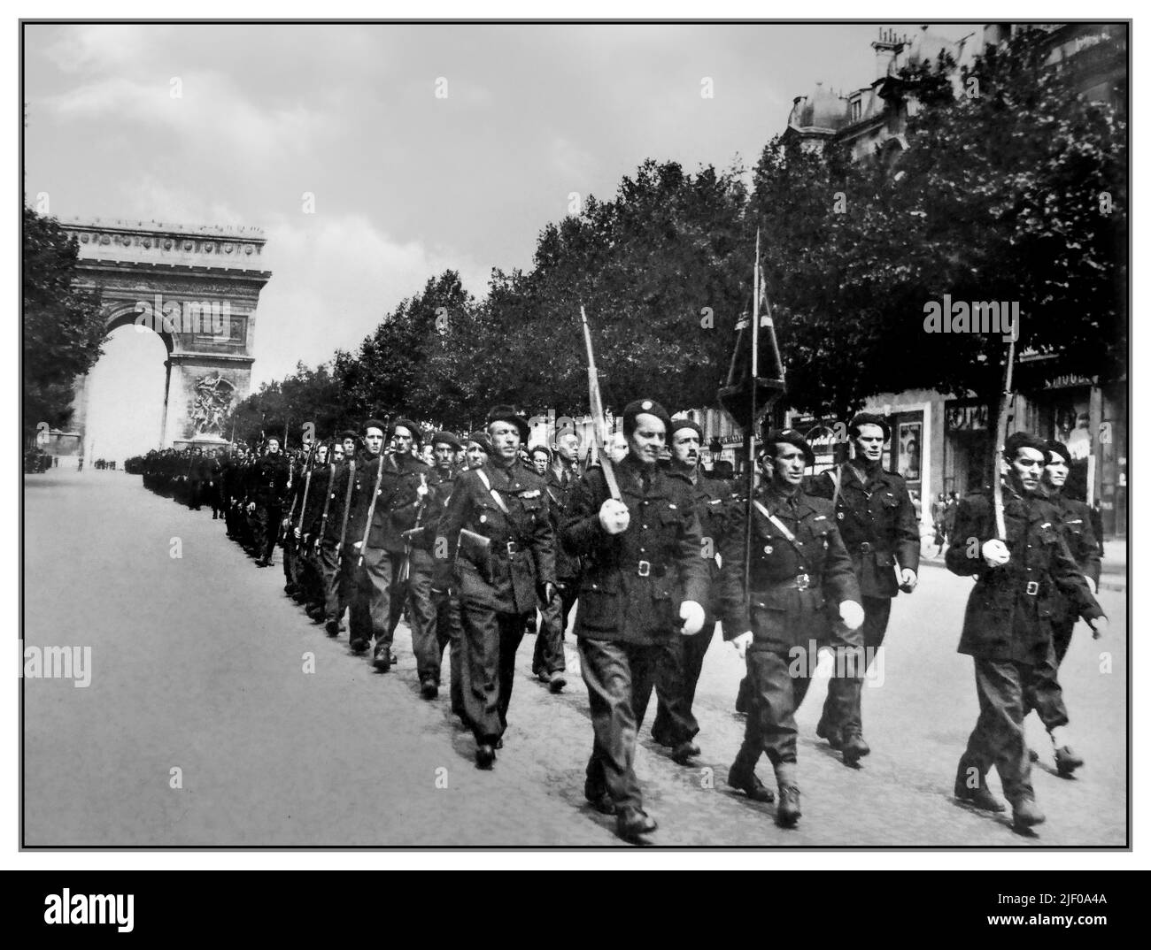 Vichy France Nazi collaborators of French Militia Battalion army march down the Champs Elysees with Arc de Triomphe in background Paris 1940s WW2 France Stock Photo