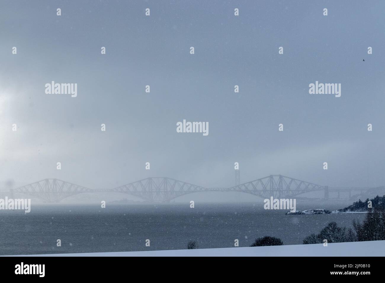 The Forth Bridge in a snow storm, from Dalgety Bay, Fife. Stock Photo