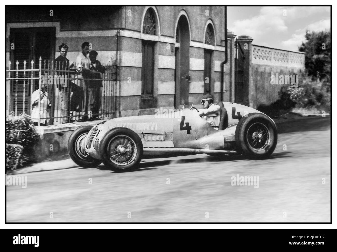 Driver Von Brauchitsch (n ° 4) in a 'Silver Arrow' Mercedes at the Circuit del Montenero.   Manfred Georg Rudolf von Brauchitsch (15 August 1905 – 5 February 2003) was a German auto racing driver who drove for Mercedes-Benz in the famous 'Silver Arrows' of Grand Prix motor racing in the 1930s. Montenero Circuit, official name: Circuito del Montenero or sometimes referred to simply as 'the Livorno Circuit', was a Grand Prix motor racing road course located at the southern outskirts of Livorno, a city on the mediterranean coast of the Tuscany region in Italy. Stock Photo