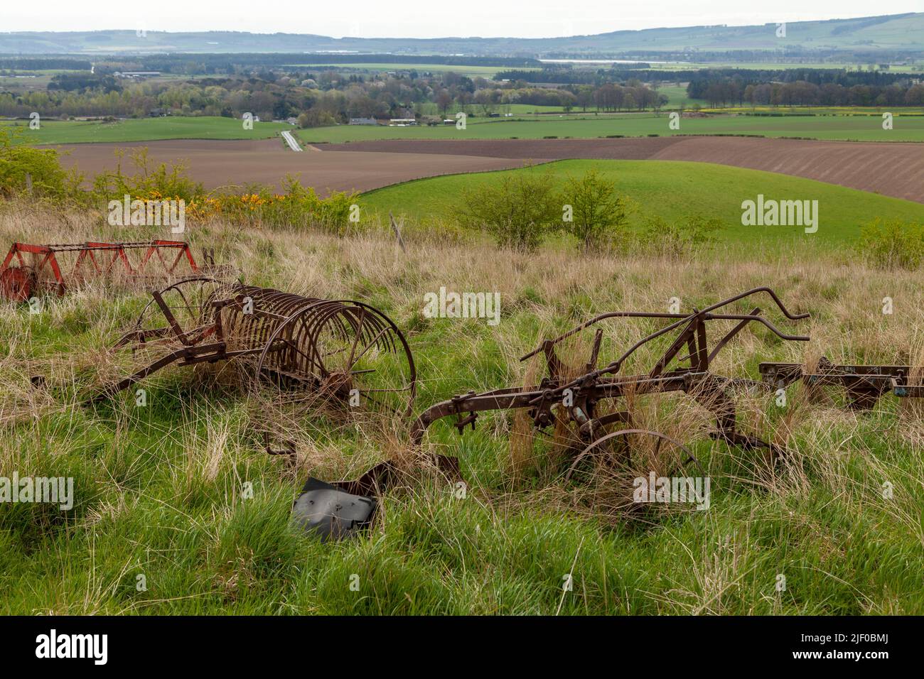 Rusty old farm machinery in a rural landscape Stock Photo